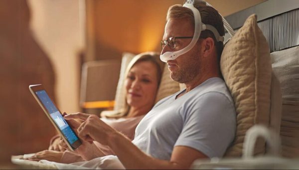 Man wearing Philips DreamWear Nasal Mask in bed using the DreamMapper app | Intus Healthcare