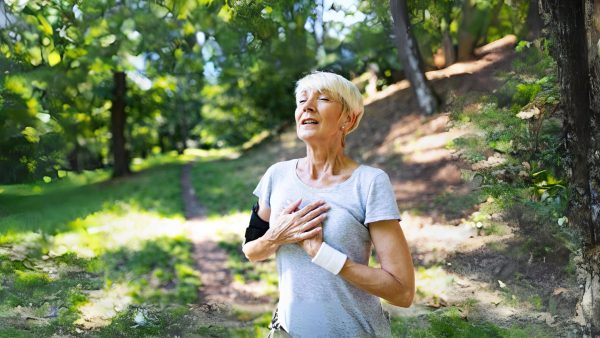 Women running in a park, holding her heart.