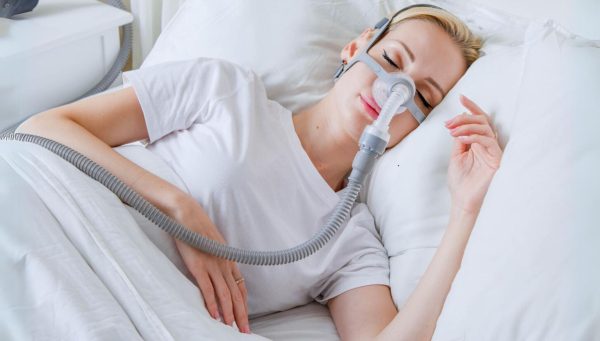 Woman wearing a BMC CPAP Mask in bed | Intus Healthcare