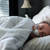 Man side sleeping using CPAP machine - CPAP Aerophagia | Intus Healthcare